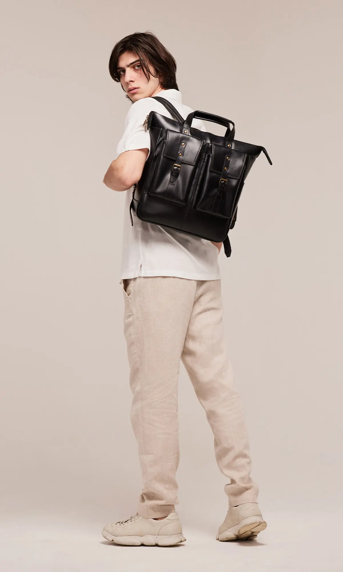 Angled three quarter view of Murphy Large black leather backpack showing soft natural leather texture, rounded shape and spacious main compartment