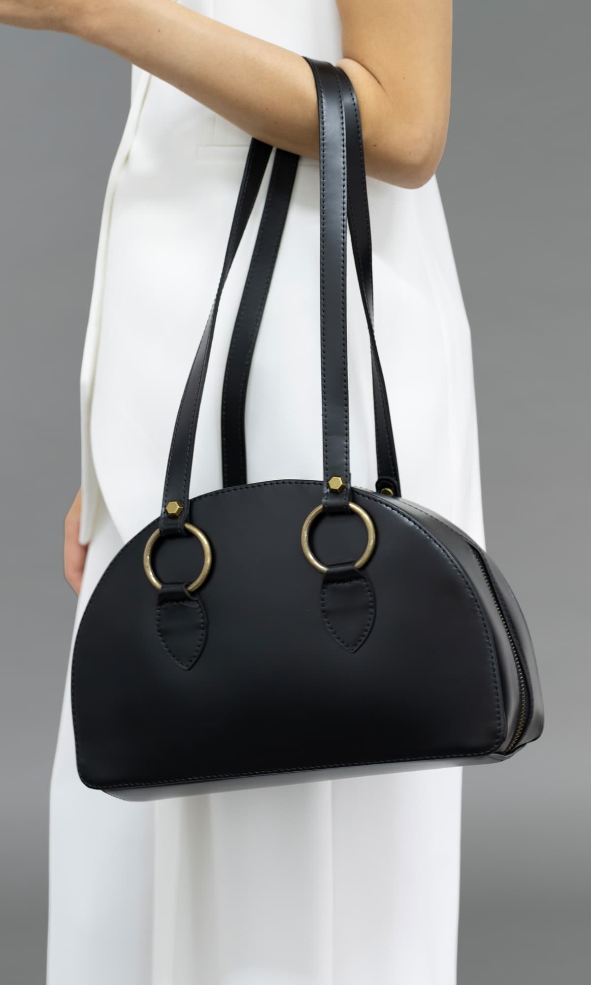 Rebecca Retro Bowling Bag in black leather — rear angle view showing the smooth leather finish, curved structure and long shoulder straps